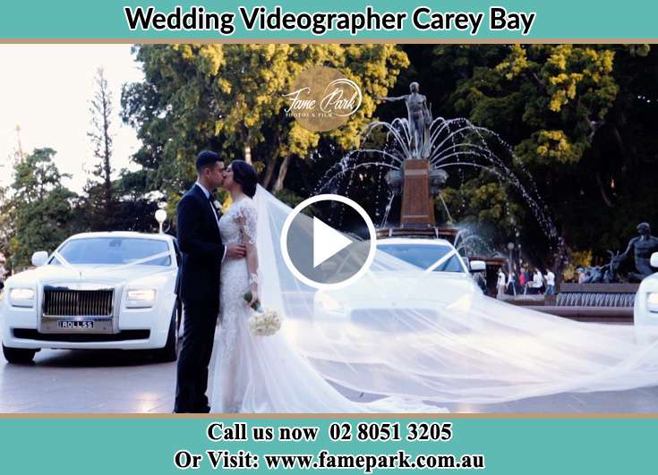 The new couple kissing near their wedding car Carey Bay NSW 2283