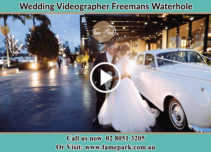 The newly weds kissing near the wedding car Freemans Waterhole NSW 2323